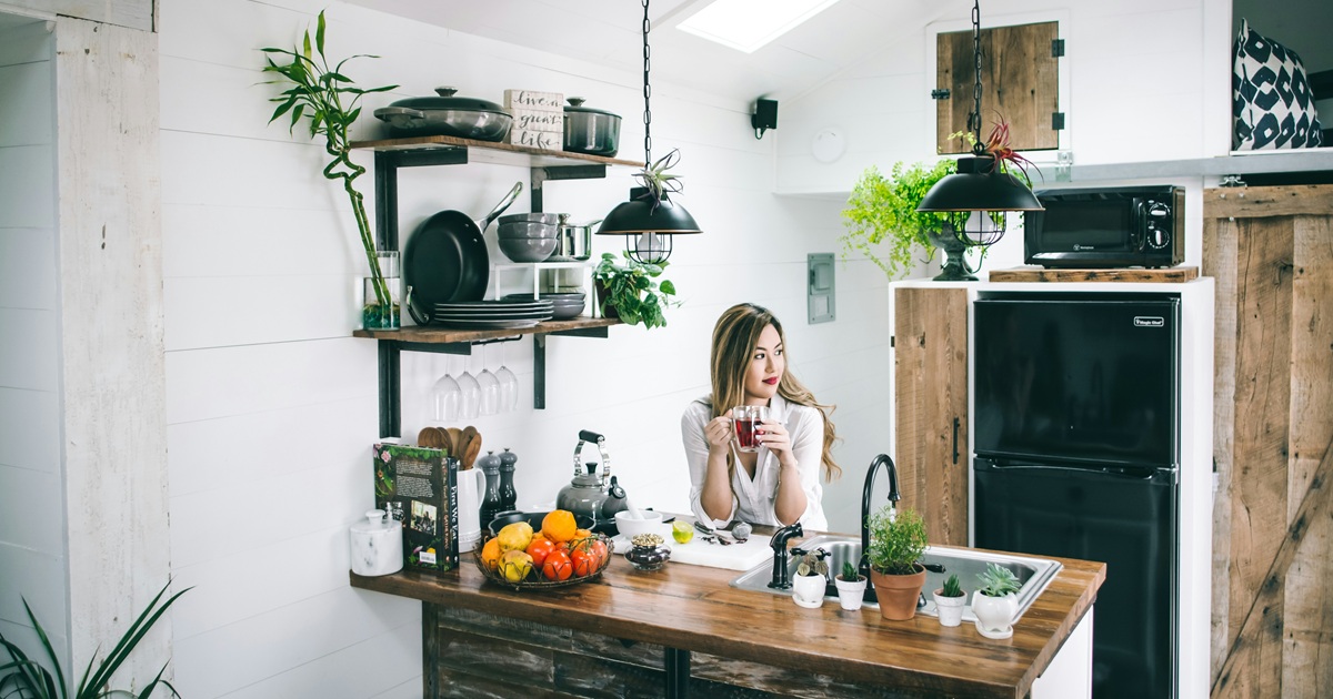 キッチンで飲み物を持ちながら考える女性