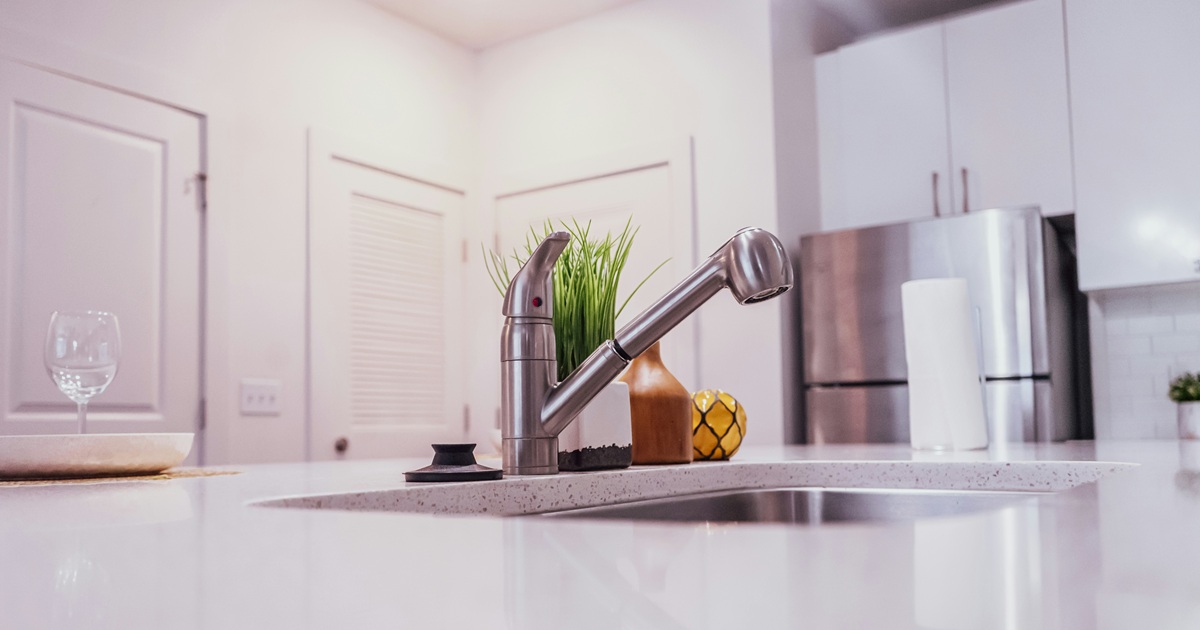 清潔感のある白いキッチンカウンターとシルバーの蛇口