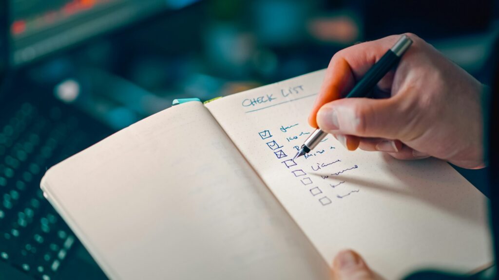 ノートにチェックリストを書き込む手元